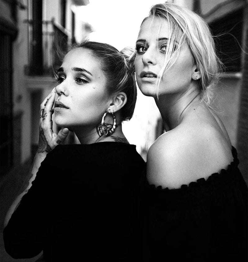 black and white portrait of two young women in Mallorca. Blonde and black hair. For a photo-magazine.